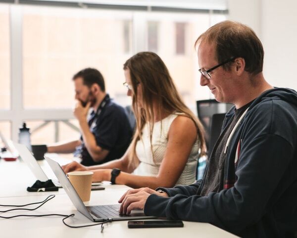 Three people hard at work on laptops at Genomics England