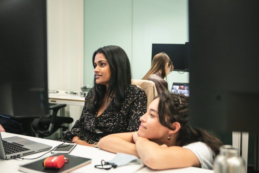 Two women working on computers at Genomics England