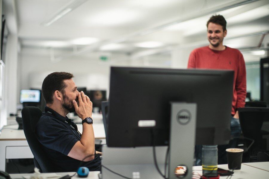 Two men working at Genomics England laughing together