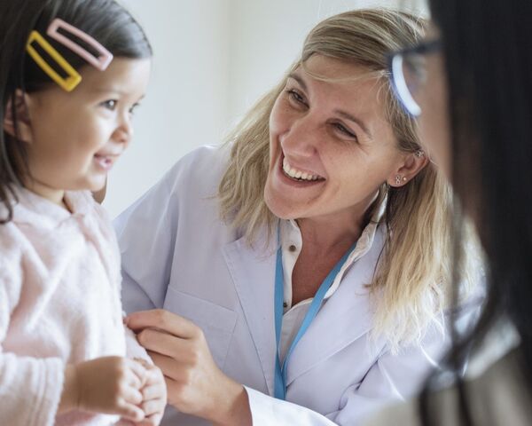 Female pediatrician smiling at young girl