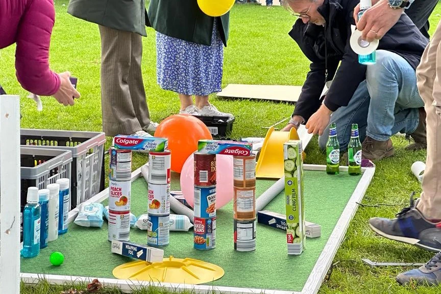 employees building mini golf holes for charity team building activity