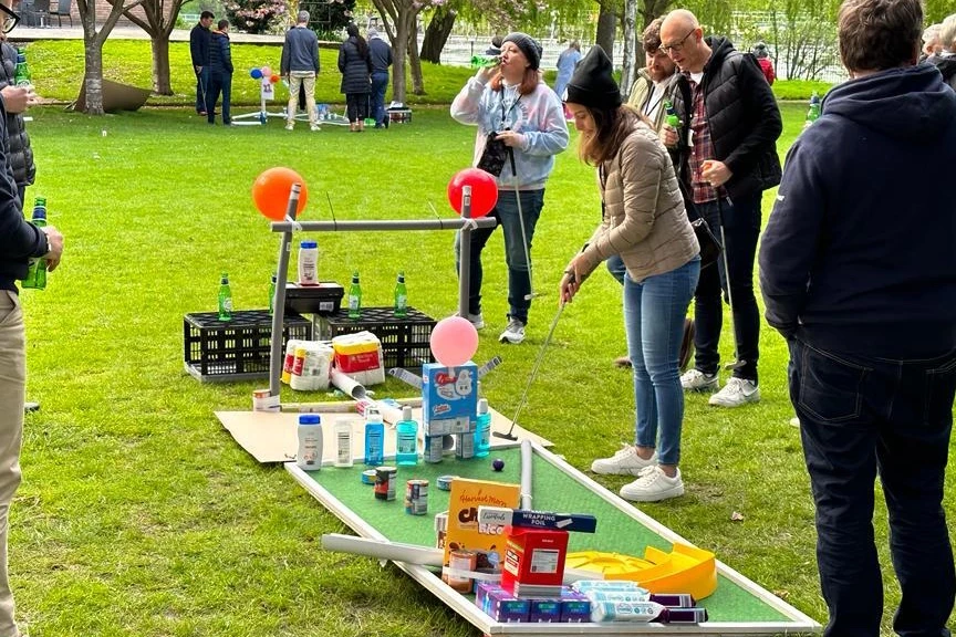 employees playing mini golf course after building the holes in charity team building