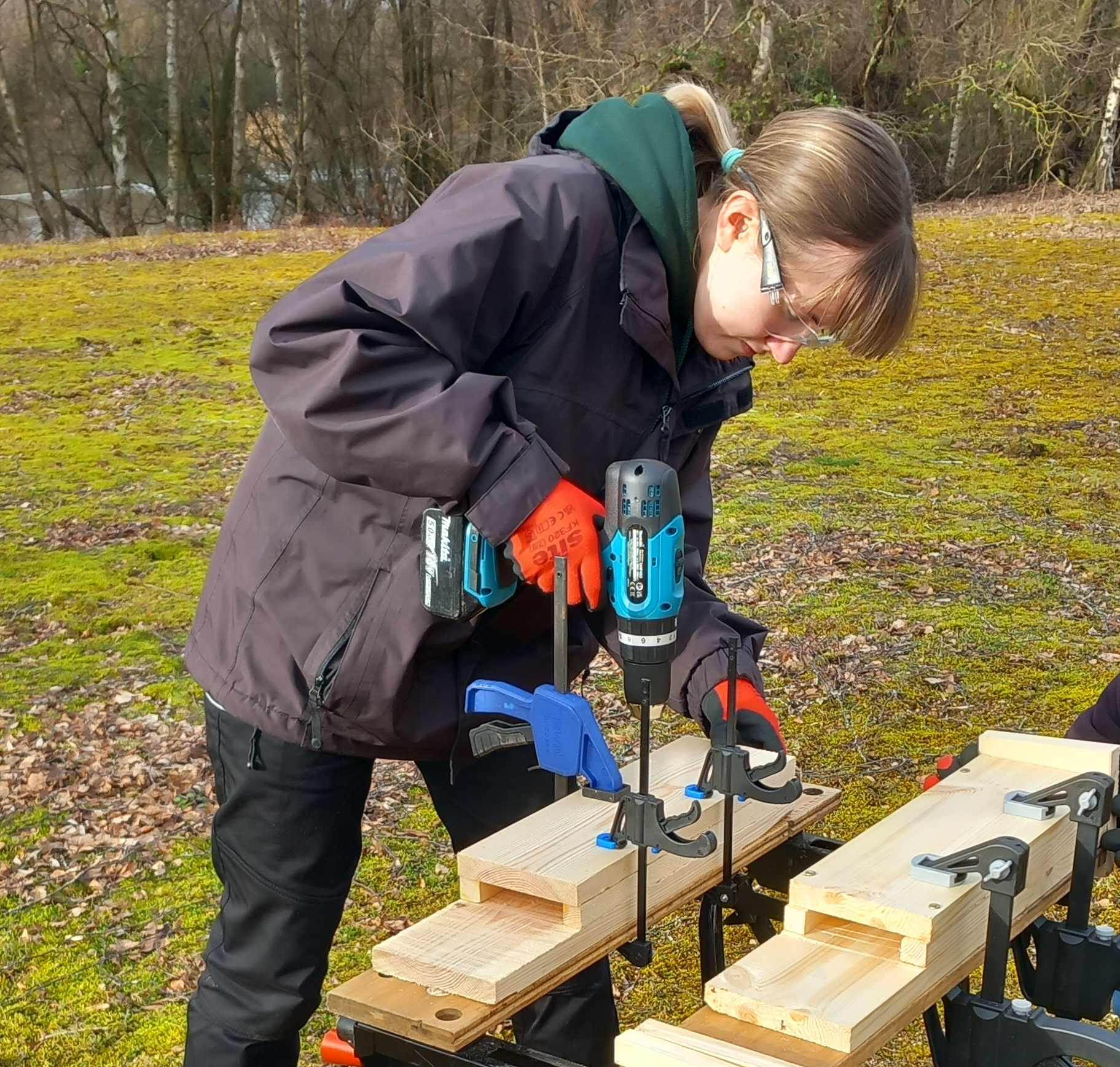 Participant using drill making a bat box outside