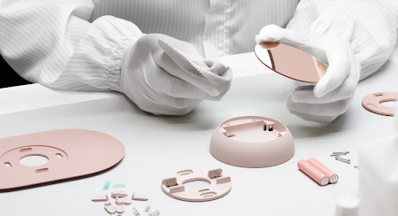 A worker builds and inspects a Nest thermostat.