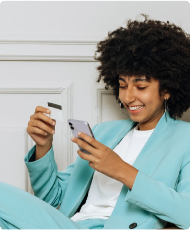 A young woman in a suit makes a mobile purchase.