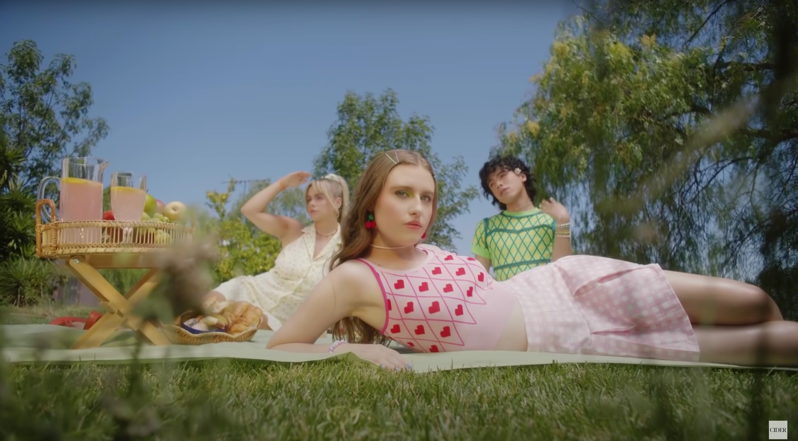 An image of three people in Cider clothing having a picnic.