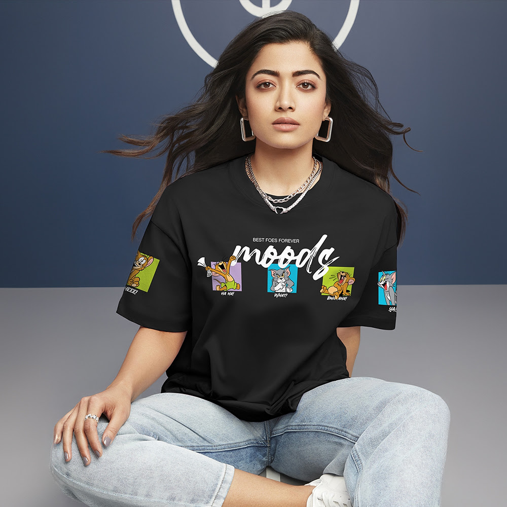 A woman wearing a black tee shirt and light blue denim sitting on the floor