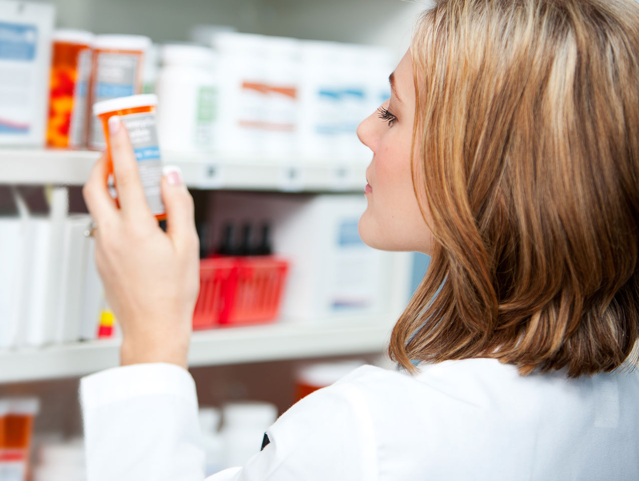 Doctor holding medicine bottle in a pharmacy