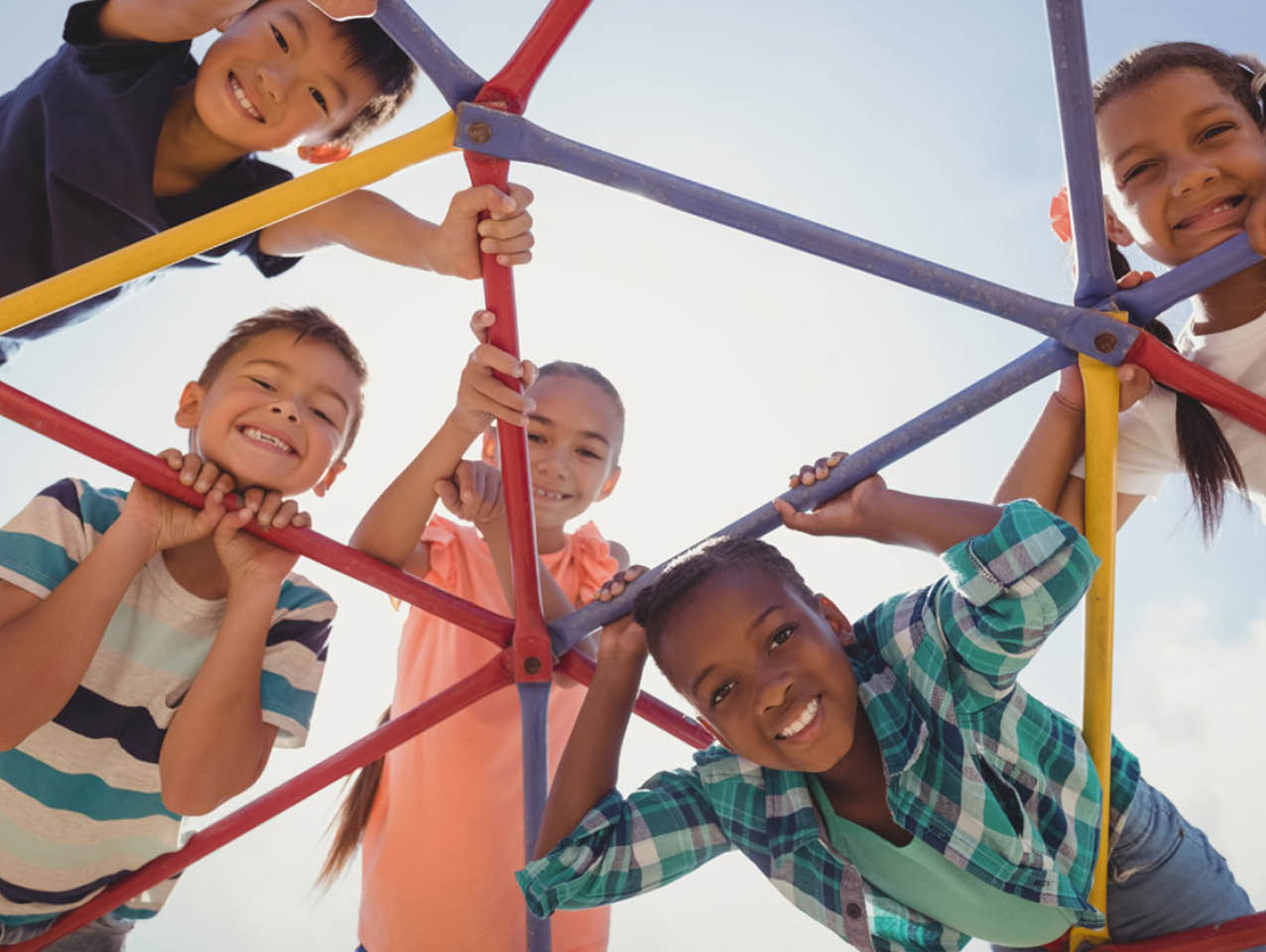 Children smile on playground structure