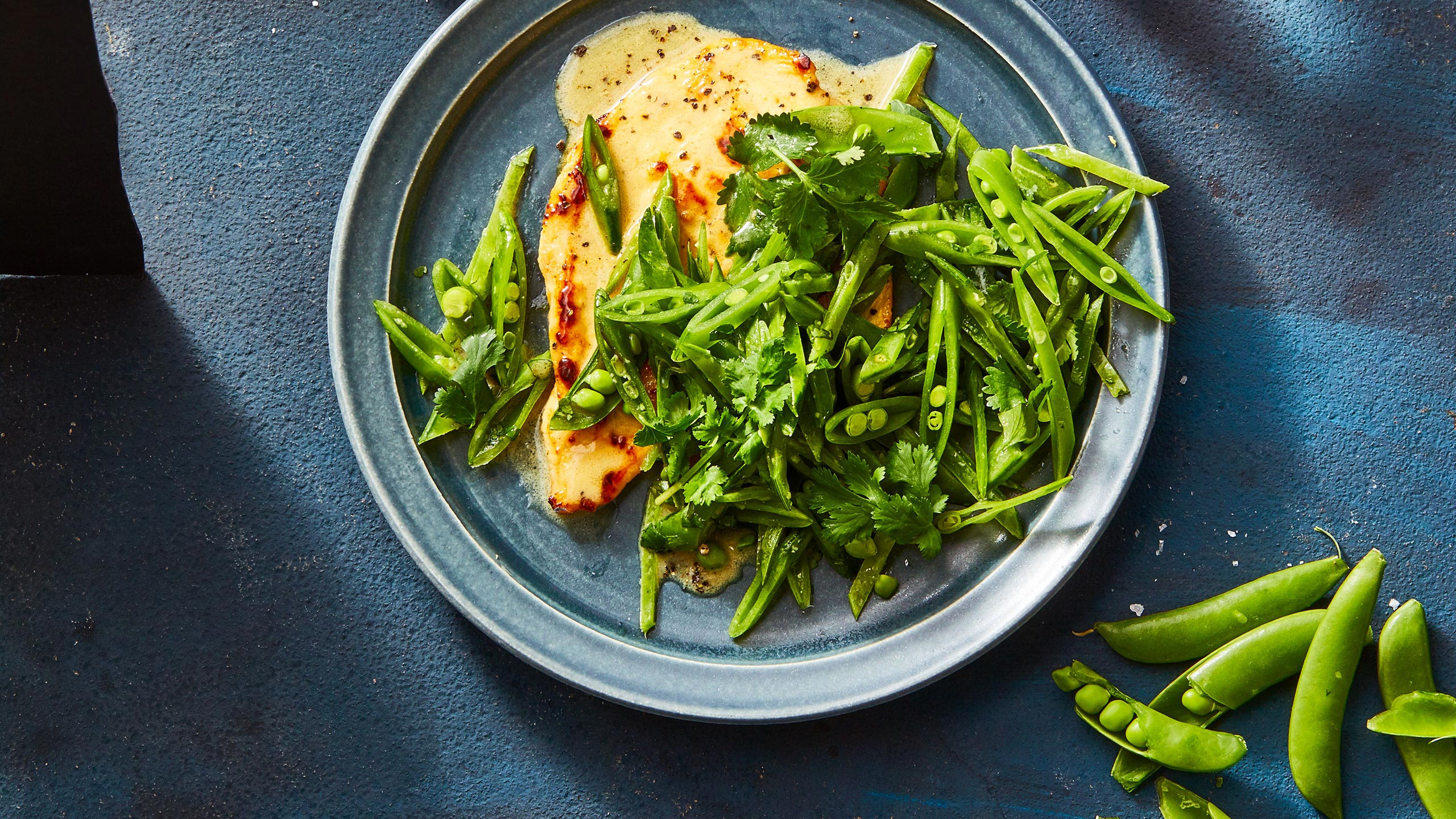 Overhead view of chicken with green vegetables on plate