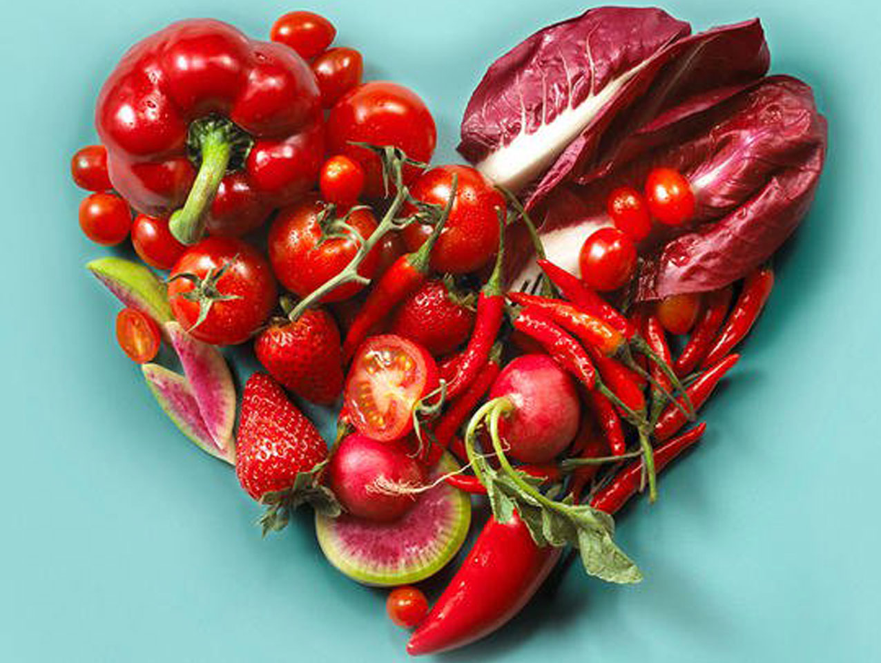 Red-colored fruits and vegetables arranged in the shape of a heart