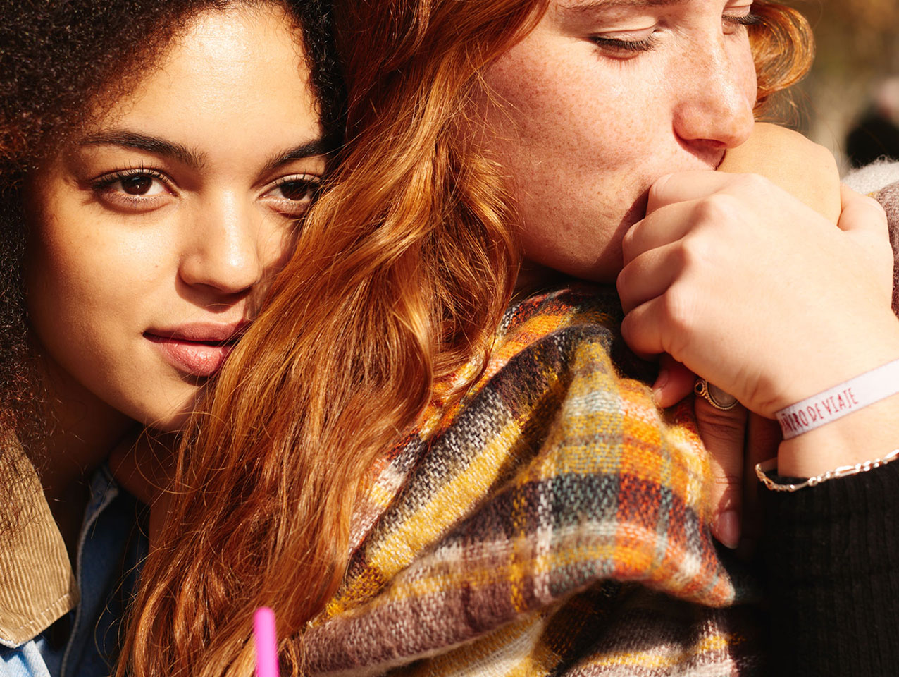 Two teenagers embrace as one kisses the other's hand