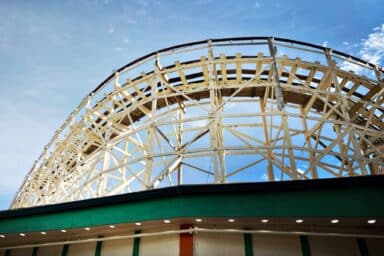 A roller coaster ascends and descends under a bright blue sky, illustrating bipolar disorder signs and symptoms