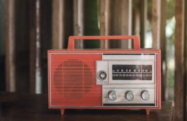 An old-fashioned radio rests on a wooden table, evoking nostalgia and symbolizing the link between hearing loss and mental health.