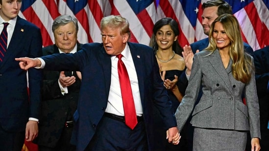 Former US President and Republican presidential candidate Donald Trump gestures at supporters after speaking as he holds hands with former US First Lady Melania Trump during an election night event at the West Palm Beach Convention Center in West Palm Beach, Florida, early on November 6. (Photo by Jim WATSON / AFP)(AFP)