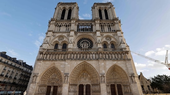 People walk in front of the Notre-Dame de Paris cathedral, ahead of its official reopening ceremony.(AFP)