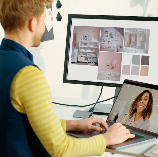 A person in front of a laptop and screen talking to someone on an online call