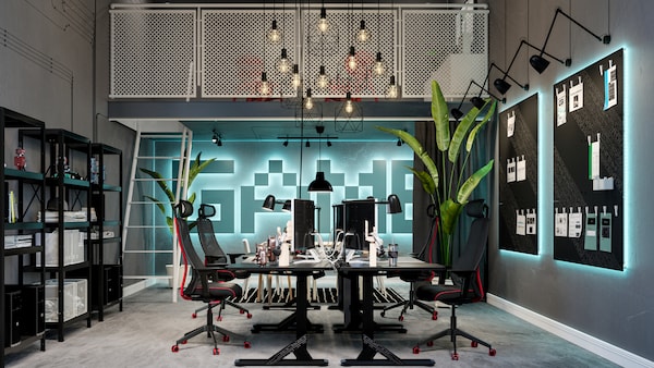 A futuristic room with a mezzanine balcony overlooking a collective workspace formed by UPPSPEL desks and MATCHSPEL chairs.