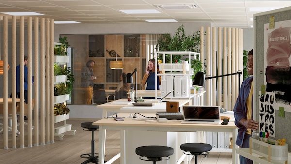 A large and modern open-plan office with MITTZON sit/stand desks placed in the middle of the space.