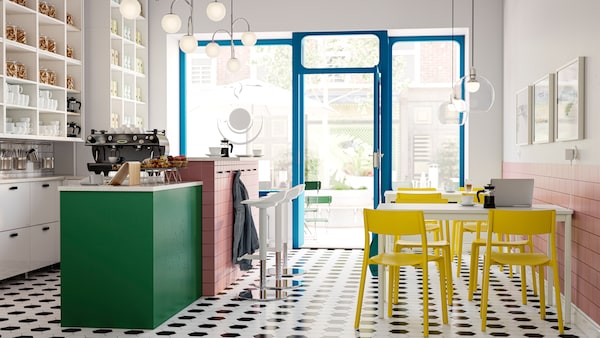 A light, airy coffee-bar interior with black-and-white tile floor, a vibrant colour scheme and large, street-facing windows.