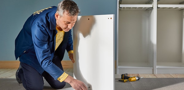 An IKEA worker putting together a cabinet