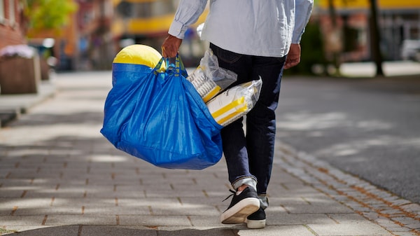 Man walking along high street with blue frakta bag