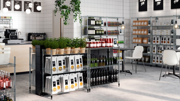 OMAR shelving units in different heights displaying packages of foods, bottles and plants tidily organised in a clean shop.