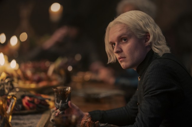 A young man with short, white-blond hair, sitting at a medieval dining table; still from "House of the Dragon."