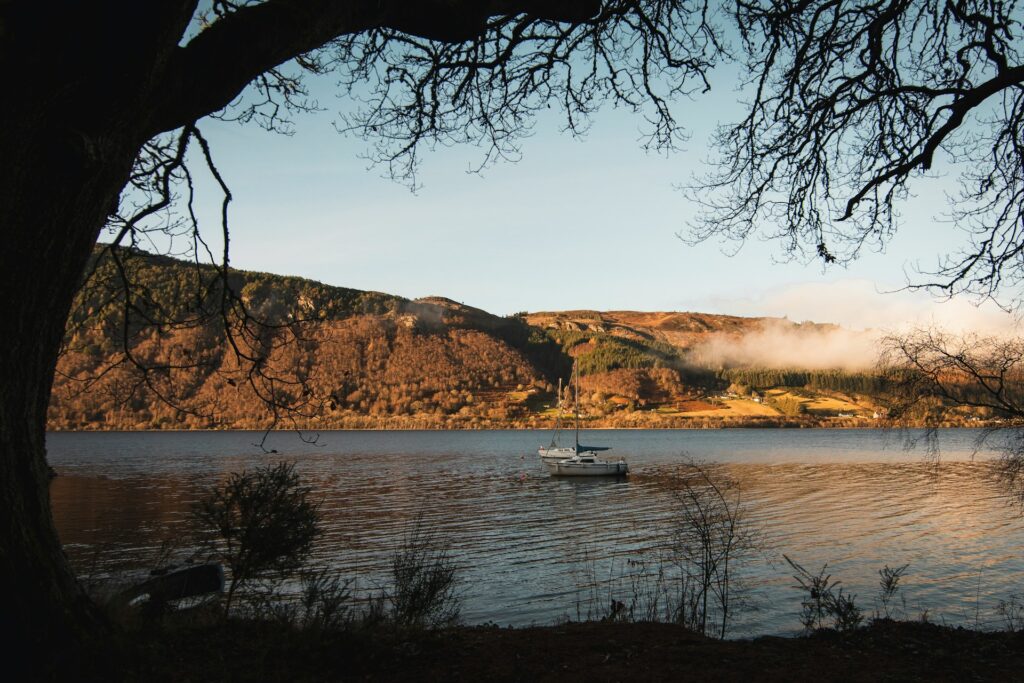 Loch Ness in the fall, viewed from the shore, with small boats visible on the water