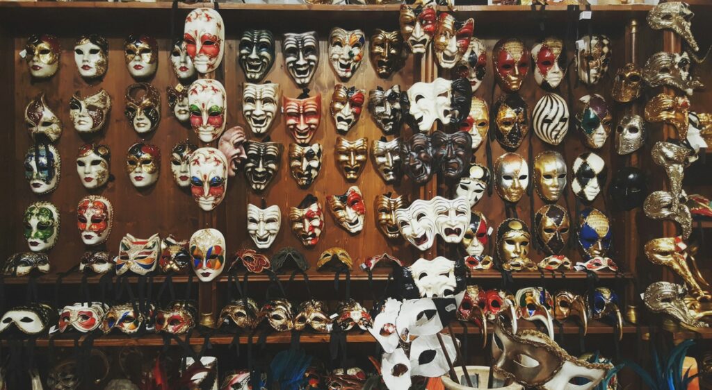 Carnival masks hanging on a wooden shop front in venice