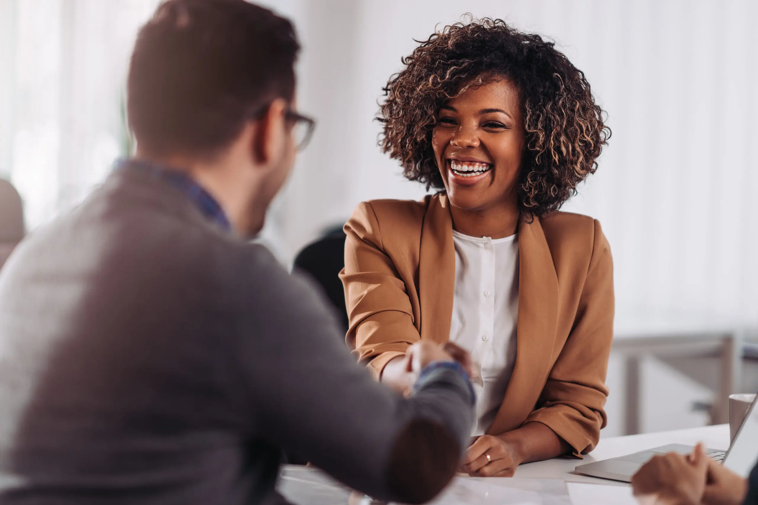 Happy businesswoman shaking hands with colleage after successful meeting