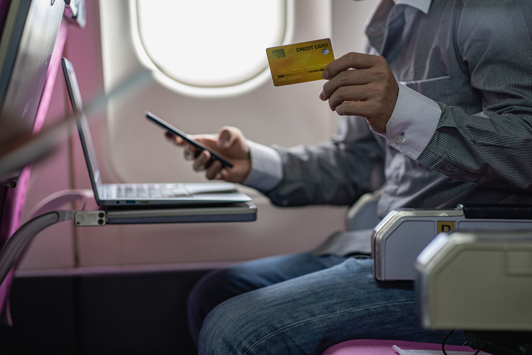 People use laptops and smartphones to pay with their credit cards for plane tickets and travel ideas.