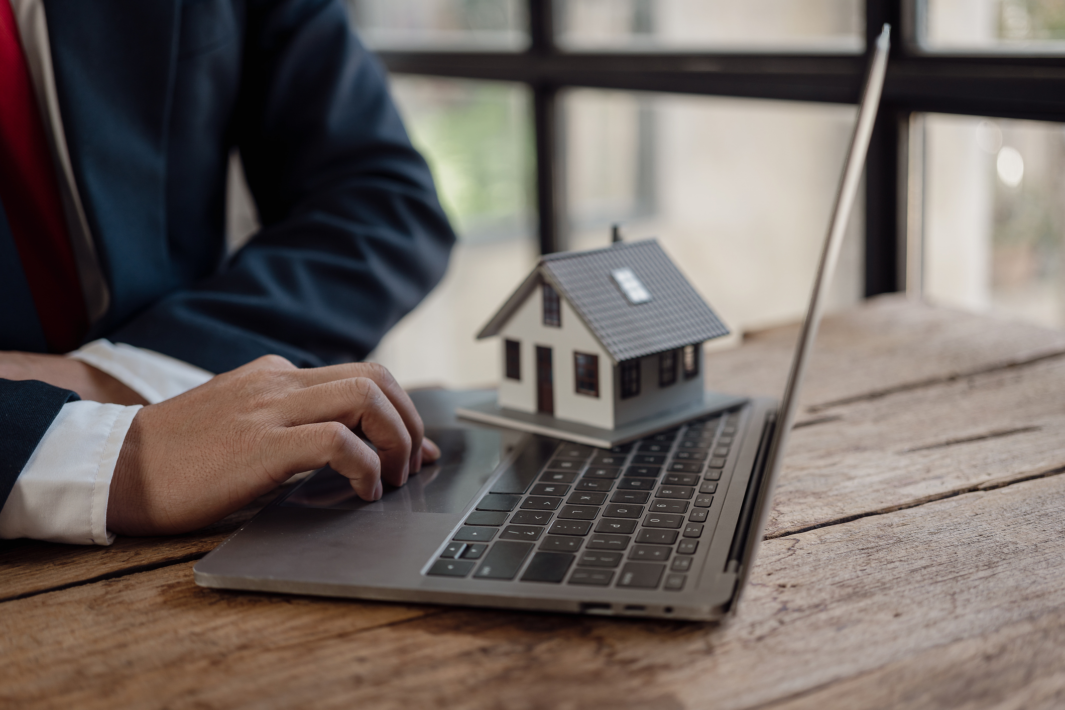 Businessman working on financial investments in the office Protection insurance provides home for protection and care, real estate sales concept, close-up