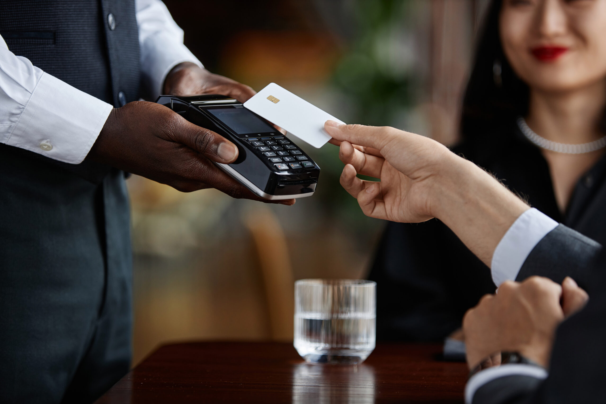 Side view close up of guest paying with credit card in luxury restaurant