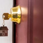 Metal silver house key in a door keyhole