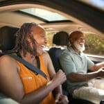 Senior Couple Enjoying Summer Day Trip Out Driving In Car Together