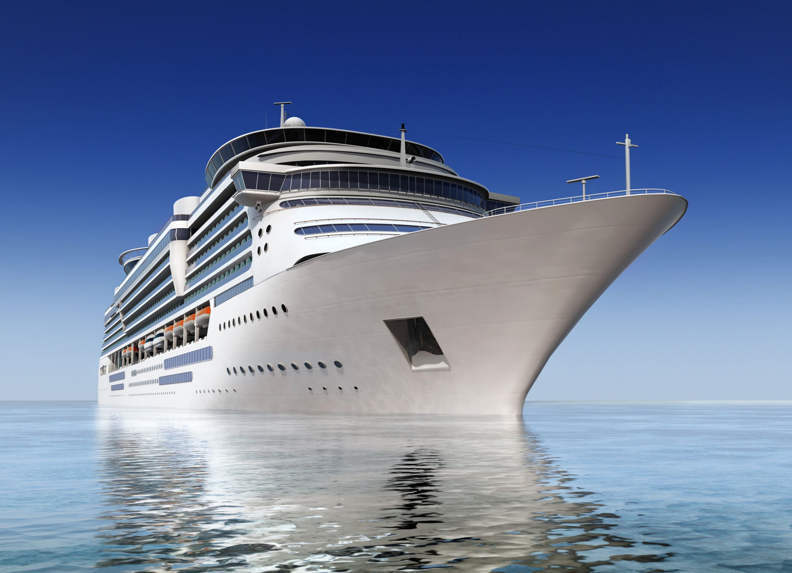 luxury white cruise ship shot at angle at water level on a clear day.