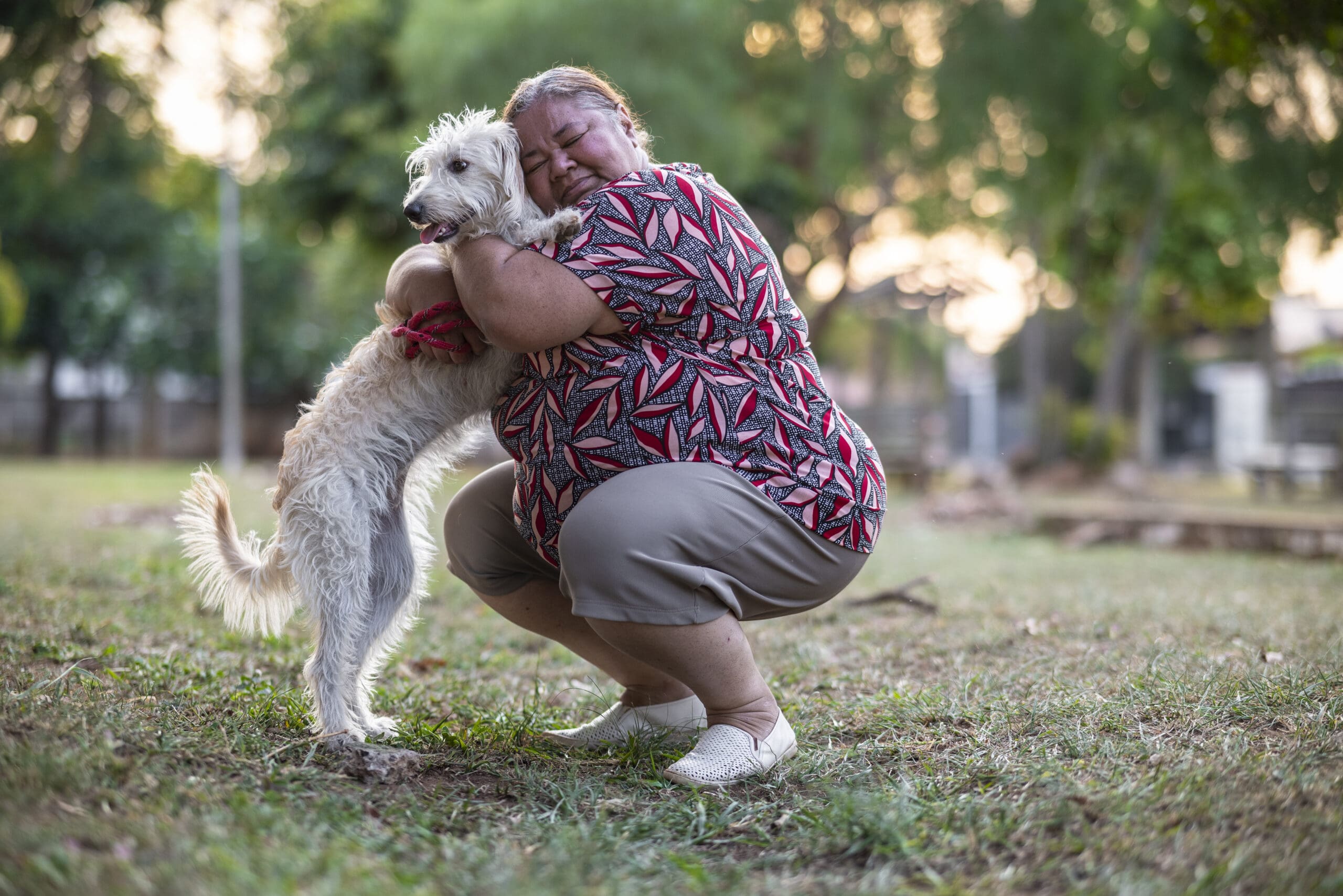 Portrait of a Latin woman taking her cute dog for a walk on the streets and in a public park, in a relaxing mood.