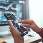 Closeup - Woman is checking Bitcoin price chart on digital exchange on smartphone, cryptocurrency future price action prediction. Another crisis is coming and prices on the charts are falling down.