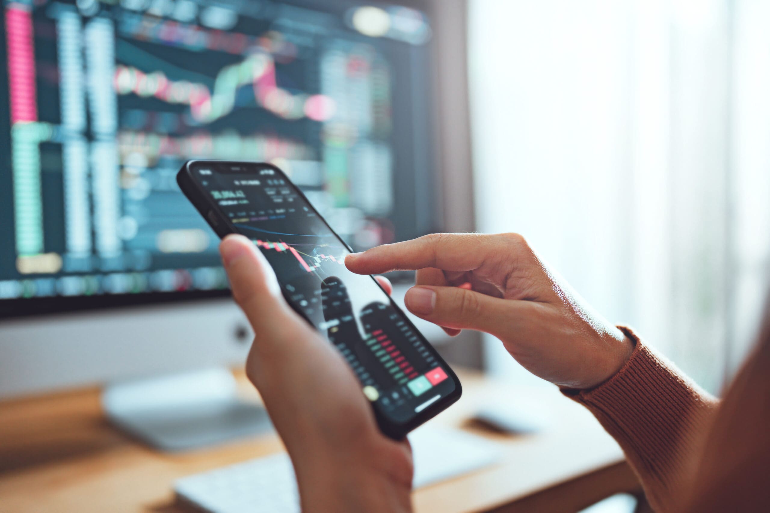 Closeup - Woman is checking Bitcoin price chart on digital exchange on smartphone, cryptocurrency future price action prediction. Another crisis is coming and prices on the charts are falling down.