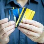 Man holding several credit cards and he is choosing a credit card to pay and spend Payment for goods via credit card. Finance and banking concept