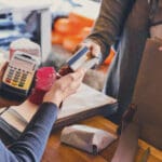 Retail, credit card payment service. Customer paying for order of cheese in grocery shop.