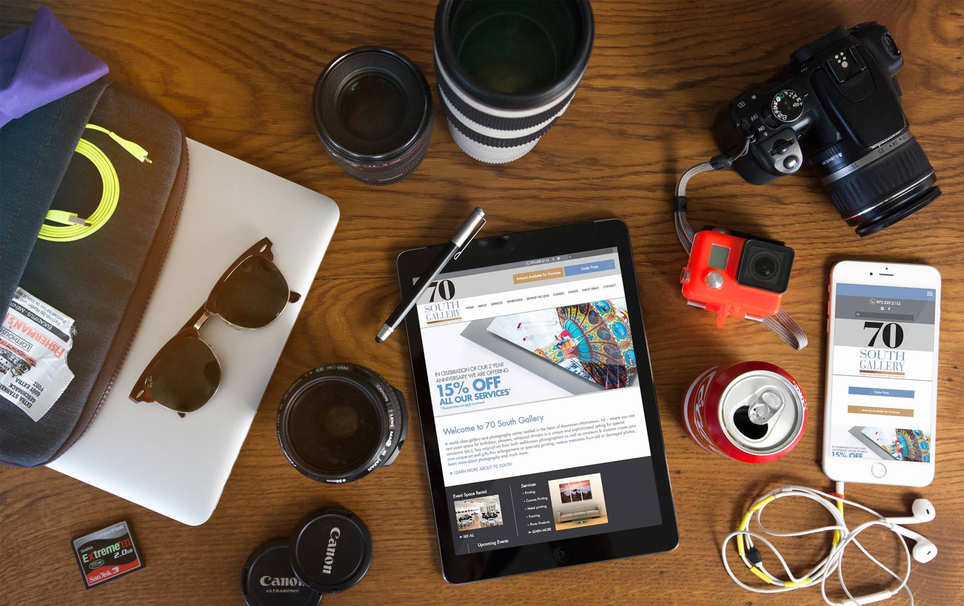 tablet and smartphone displaying 70 South Galley website surrounded by photography-related equipment