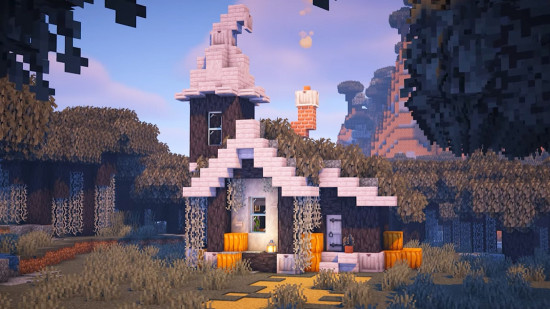 A gray, white, and orange Minecraft house build within a Pale Garden biome.