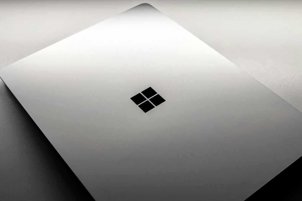 Windows laptop with lid closed on ominous white background surface hero