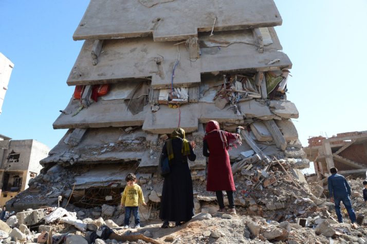 People stand among the rubble of damaged buildings following heavy fighting in the Kurdish town of Cizre | Ilyas Akengin/AFP via Getty Images