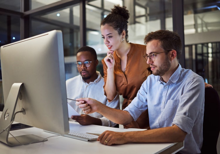 Colleagues-two-men-and-woman-looking-at-the-screen-considering-pricing-software-in-the-office