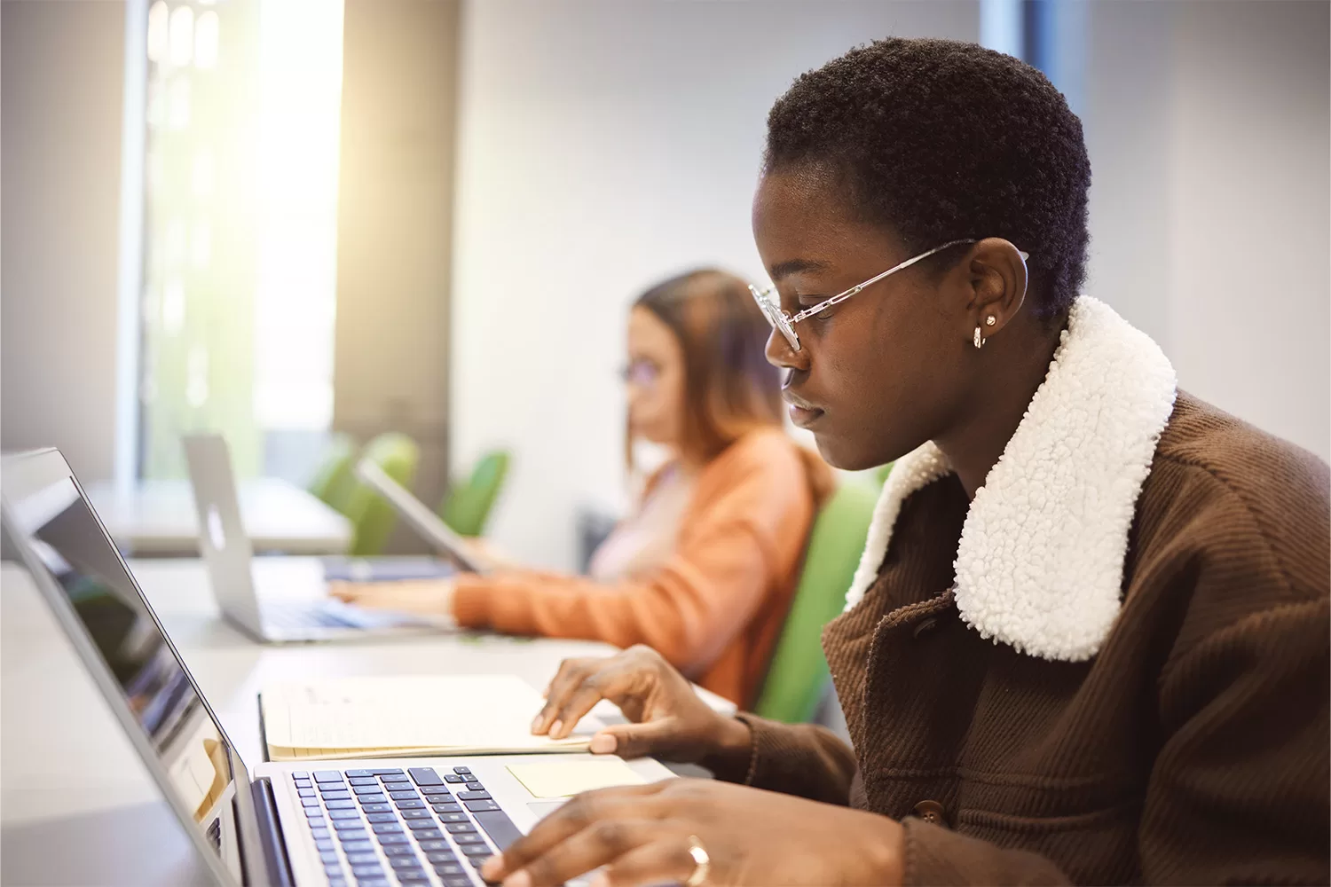 Student sitting in front of a laptop reading an article.