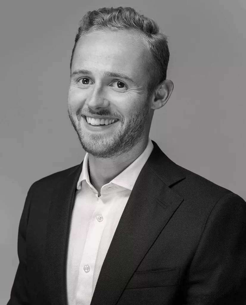 A black and white portrait image of Matteo Quacquarelli wearing a suit and smiling into the camera.