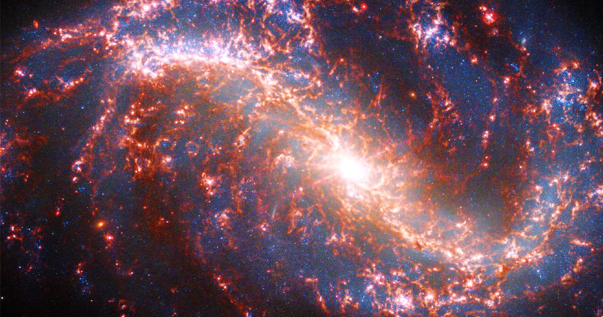 Image of a spiral galaxy strewn with ribbons of pink light.]